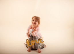 Toddler in studio photo shoot in Pasadena, California with valentine day themed props, love sign