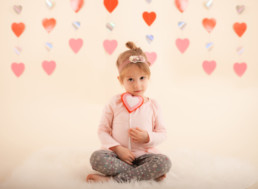 Toddler in studio photo shoot in Pasadena, California with valentine day themed props, heart backdrop